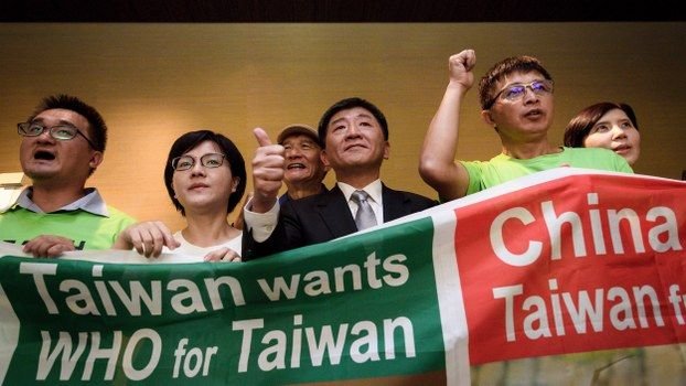 Bộ trưởng Y tế Đài Loan Chen Shih-chung (áo đen, giữa) trong một cuộc biểu tình kêu gọi WHO cho phép Đài Loan tham dự hội nghị ở Geneva, Thụy Sĩ, ngày 21/5/2018. Ảnh: AFP.